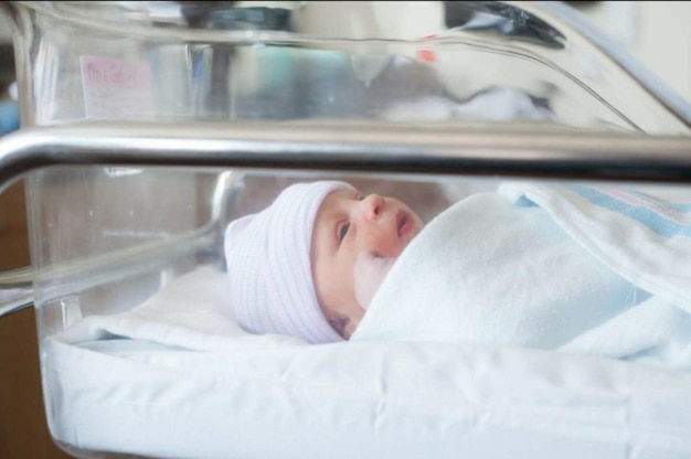 Foto primer plano de una niña durmiendo en una incubadora