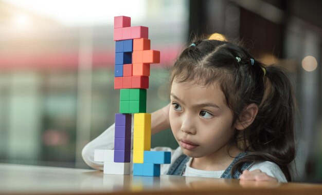 Foto primer plano de una niña jugando con bloques de juguete en la mesa