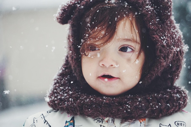 Primer plano de una niña linda con un sombrero de punto durante el invierno