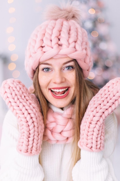 Primer plano de niña con pecas en sombrero rosa bufanda y guantes smi