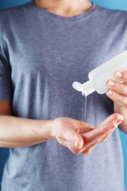 Primer plano de una niña sosteniendo un gel desinfectante en sus manos. Tratamiento antiséptico de manos de bacterias Desinfectante.