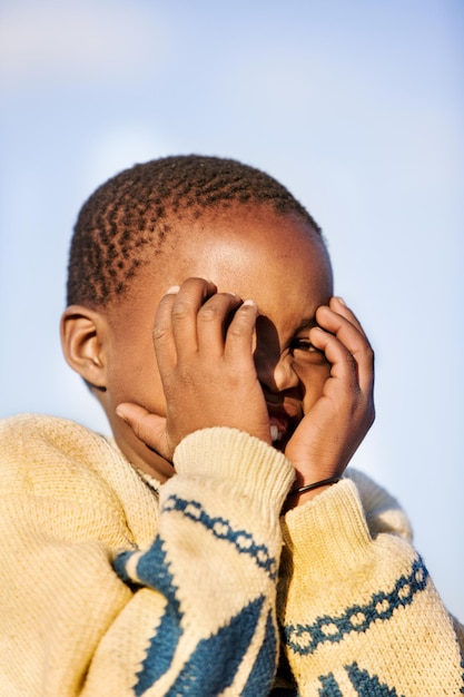 Primer plano de un niño alegre contra un cielo despejado