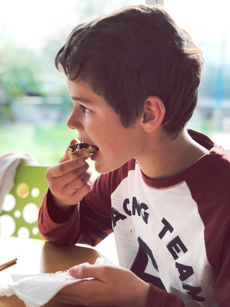 Foto primer plano de un niño comiendo comida en la mesa