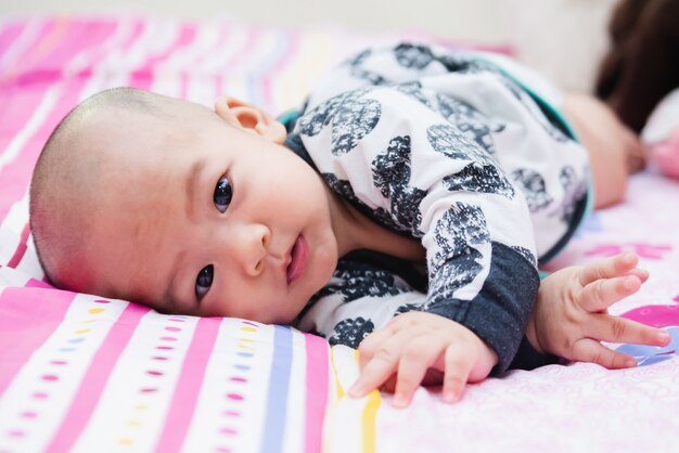 Primer plano de niño feliz jugando sobre la cama en una mañana relajada