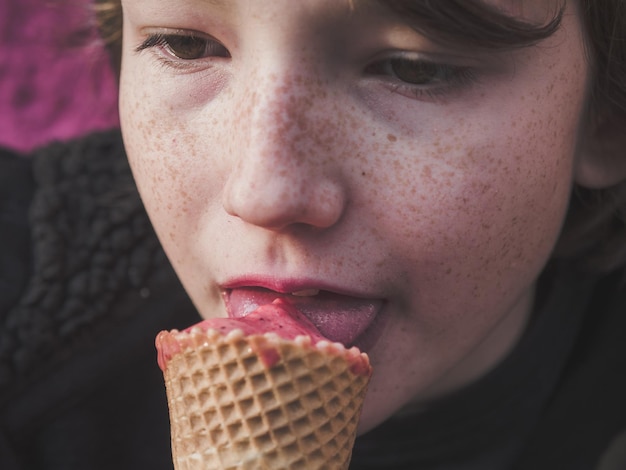 Primer plano de un niño lamiendo helado.
