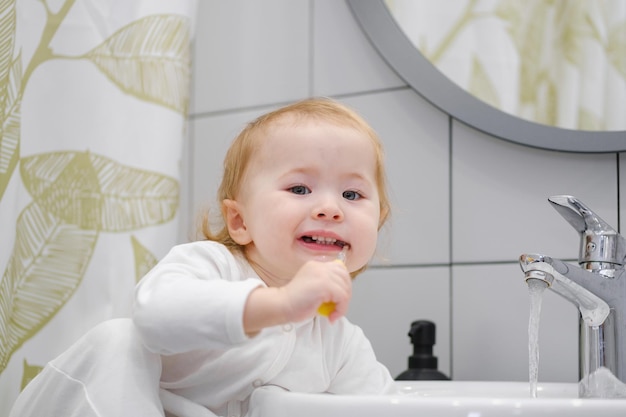 Primer plano de un niño lindo cepillarse los dientes Higiene personal y dental Mirando a la cámara y sonriendo