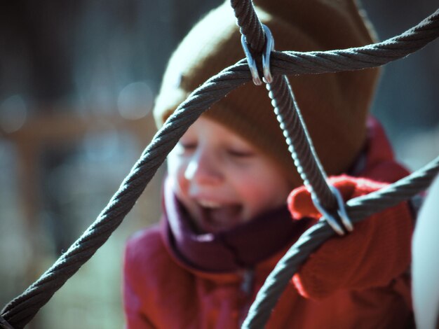 Foto primer plano de un niño lindo visto a través de la valla