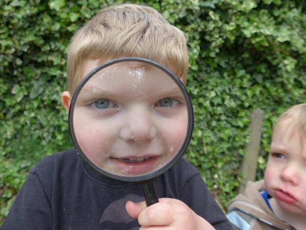 Primer plano de un niño mirando a través de una lupa