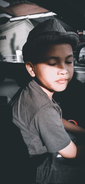 Primer plano de un niño con los ojos cerrados sentado en un coche
