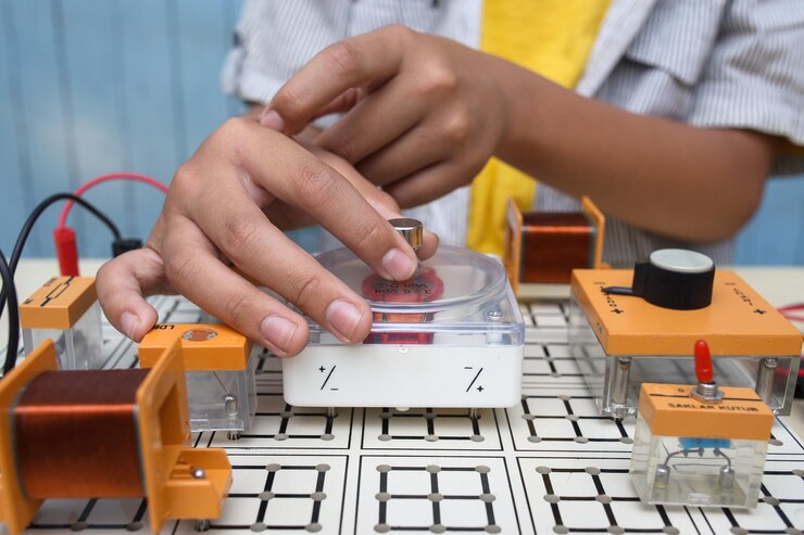 Foto primer plano de un niño que trabaja con circuitos, cables, motor de computadora en su proyecto ciencia tecnología e