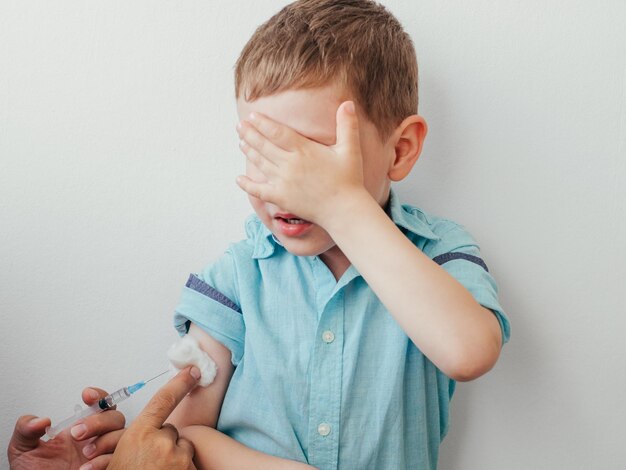 Foto primer plano del niño recibiendo la inyección