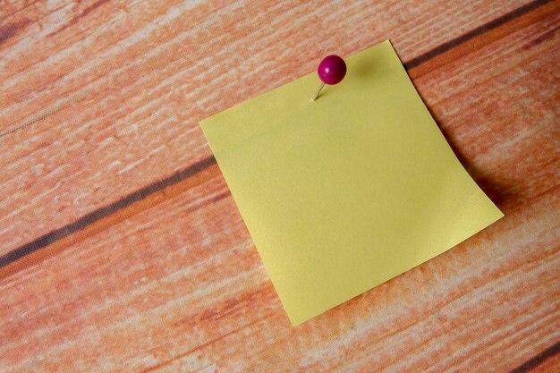 Foto primer plano de una nota adhesiva amarilla en una mesa de madera