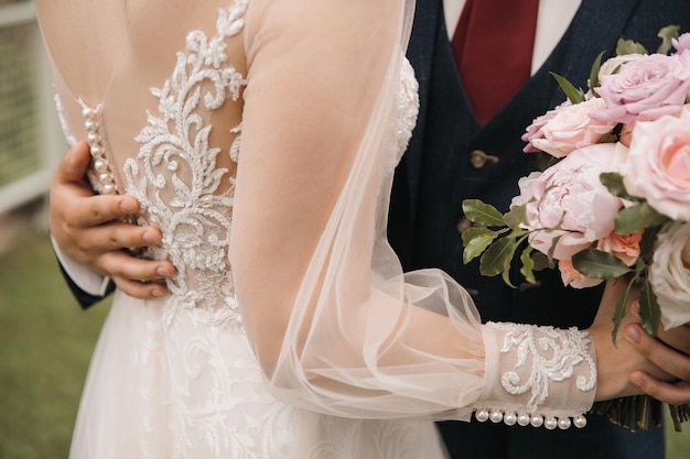 El primer plano de la novia y el novio se centran en la espalda y el ramo de la novia