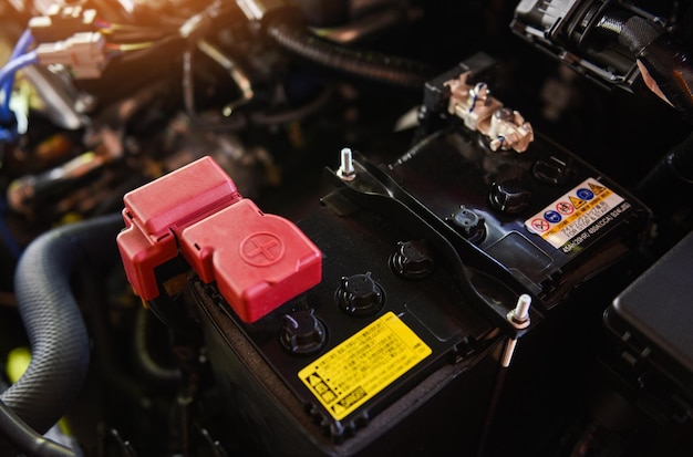 Foto primer plano de la nueva batería del automóvil en la sala de máquinas del mecánico de la batería del automóvil