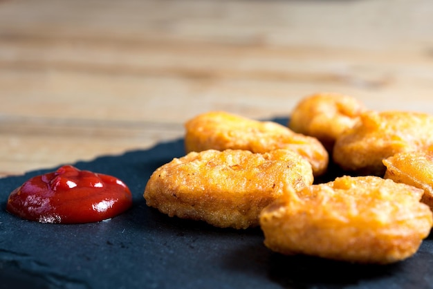Primer plano de nuggets frescos con ketchup servidos en la mesa