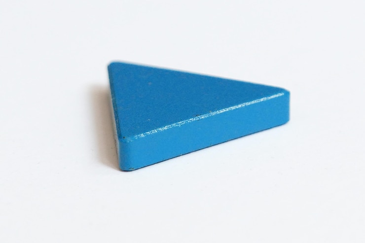 Foto primer plano de un objeto de forma triangular azul sobre un fondo blanco