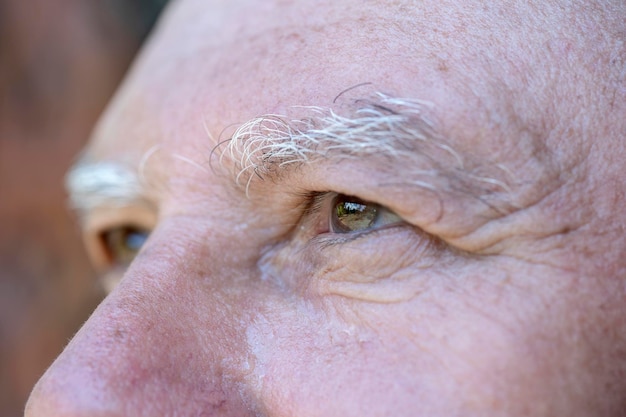 Primer plano del ojo del anciano caucásico Retrato del anciano al aire libre Cara masculina caucásica fondo cerrar ojos macro