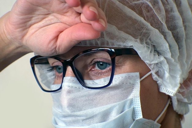 Foto primer plano de ojos de mujer en gafas que reflejan una pantalla azul de computadora en funcionamiento