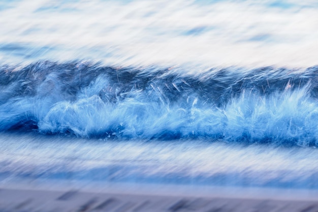 Primer plano de la ola de agua que fluye contra el cielo azul