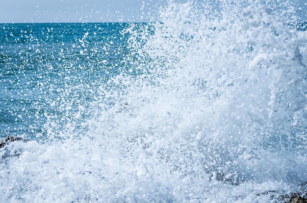 Primer plano de las olas del mar rompiendo en las rocas de la playa de Vilanova y la Geltru.