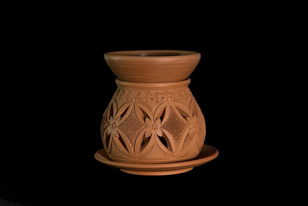 Primer plano de una olla de arcilla contra un fondo negro