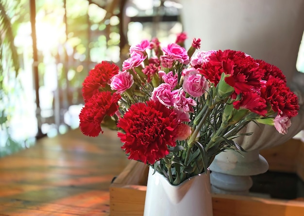 Primer plano de una olla de flores rojas en la mesa