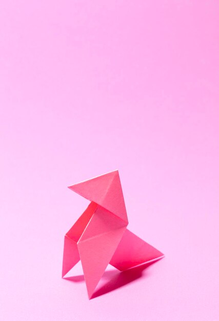 Primer plano de un origami sobre un fondo rosado
