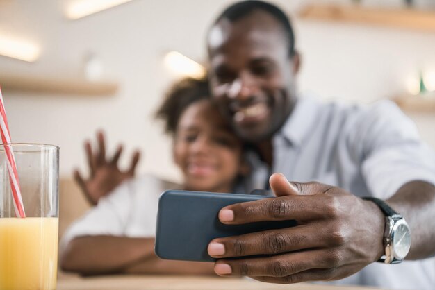 Primer plano de padre afroamericano e hija tomando selfie