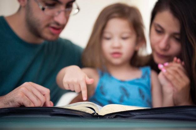 Foto primer plano de un padre con su hija leyendo la biblia