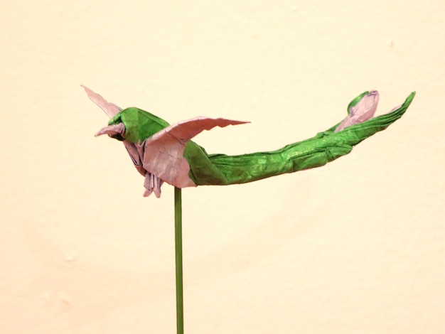 Foto primer plano de un pájaro origami contra la pared