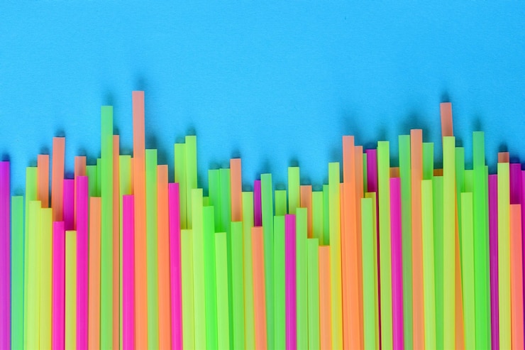 Foto primer plano de pajitas de beber multicolores contra un fondo azul