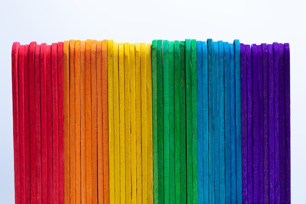 Foto primer plano de palos de madera de colores dispuestos contra un fondo blanco