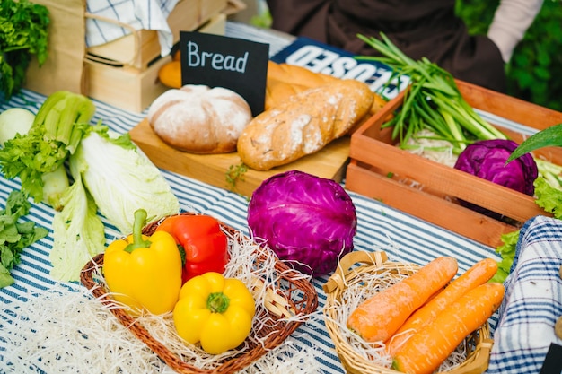 Primer plano de pan casero orgánico fresco, hierbas y verduras en el mercado agrícola