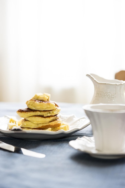 Primer plano de panqueque de manzana con té servido en la mesa