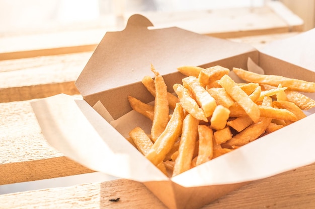Primer plano de papas fritas frescas en una caja de cartón en la mesa