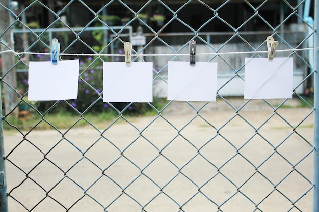 Foto primer plano de un papel colgado en una valla de enchaines