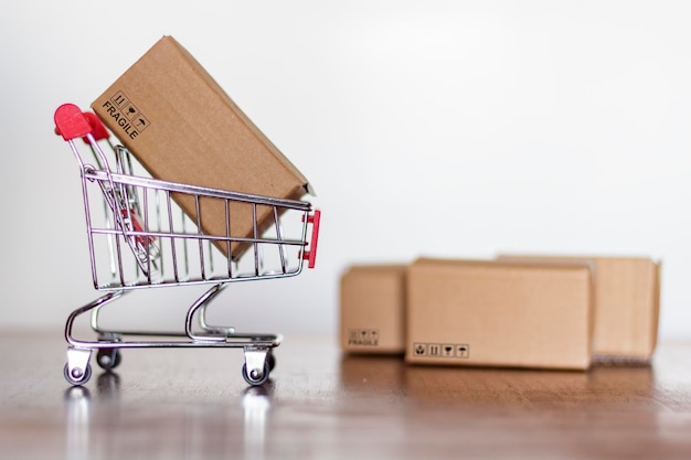Primer plano de un paquete en el carrito de compras en la mesa contra un fondo blanco