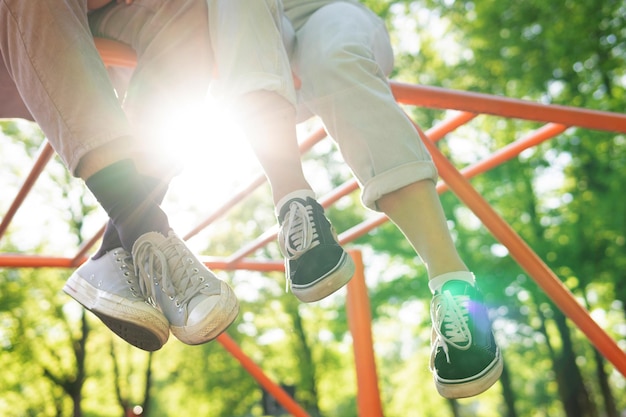 Primer plano de un par de pies adolescentes en un patio de recreo en un parque de la ciudad