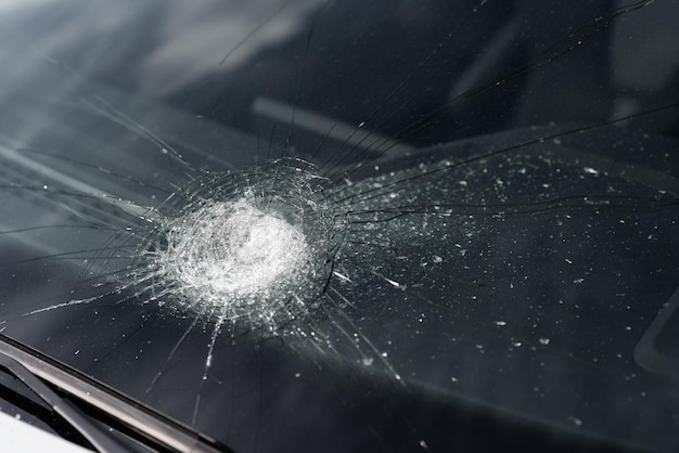 Primer plano de un parabrisas roto en un coche Grietas en el cristal