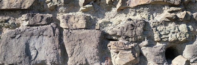 Primer plano de la pared de piedra vieja fondo roca oscura superficie naturaleza textura gris telón de fondo
