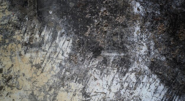 Un primer plano de una pared sucia con moho negro