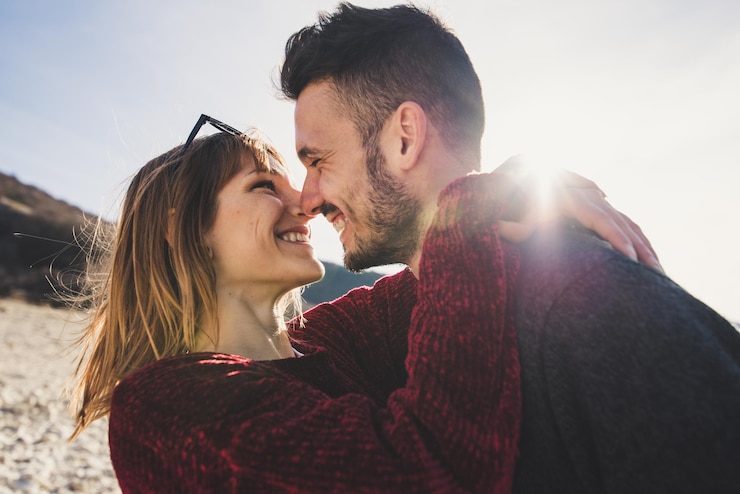 Foto primer plano de una pareja feliz de pie contra el cielo