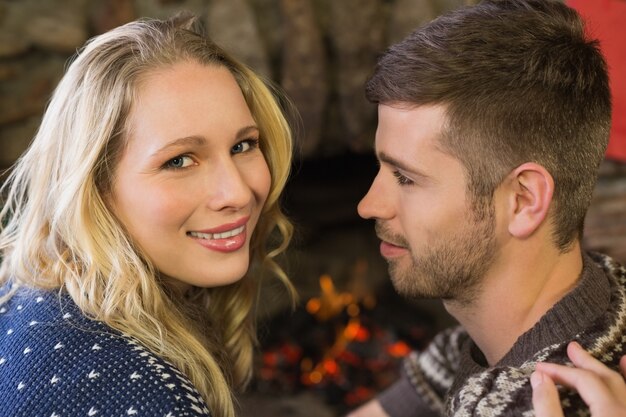 Primer plano de una pareja romántica frente a la chimenea