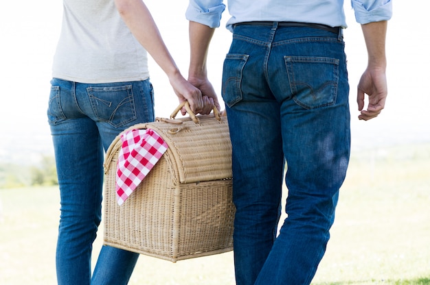 Primer plano de una pareja sosteniendo una cesta de picnic