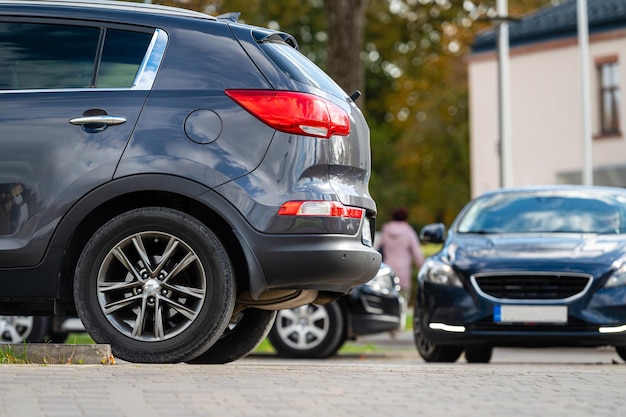 Primer plano de la parte trasera o trasera del estacionamiento de automóviles en el área de estacionamiento de línea cerca de la calle en la noche del crepúsculo