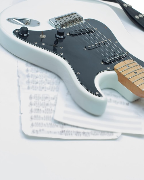 Primer plano de partituras y guitarra en una foto de fondo blanco con espacio de copia