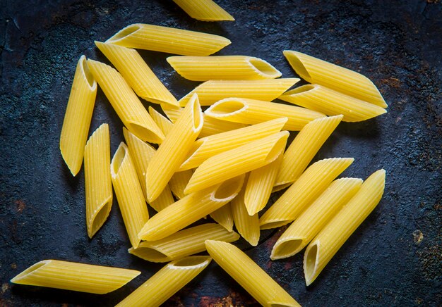 Primer plano de la pasta cruda de penne en la mesa