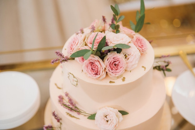 Primer plano de un pastel delicado en tonos polvorientos con flores rosas