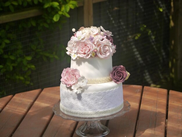 Primer plano de un pastel con glaseado floral en la mesa
