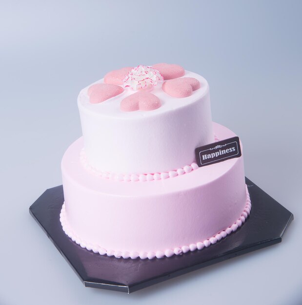 Foto primer plano de un pastel rosado contra un fondo blanco